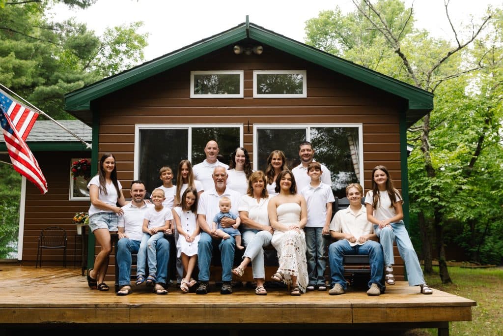 Three generations of the Soehl family gathered on the deck of the family cabin beside an American flag