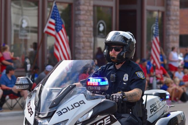 A Sioux Falls police officer riding a department motorcycle in a community parade